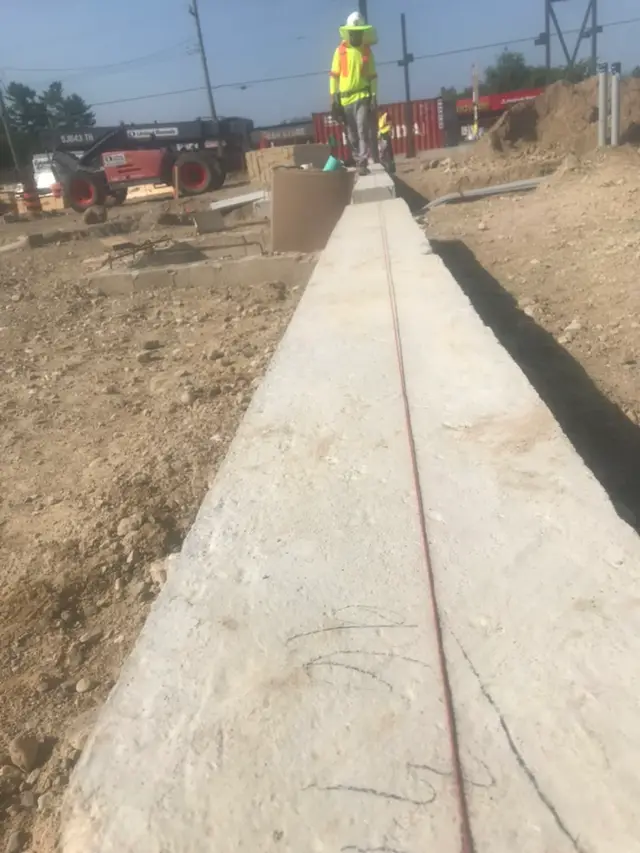 Elora site during early construction — fresh concrete curb and servicing