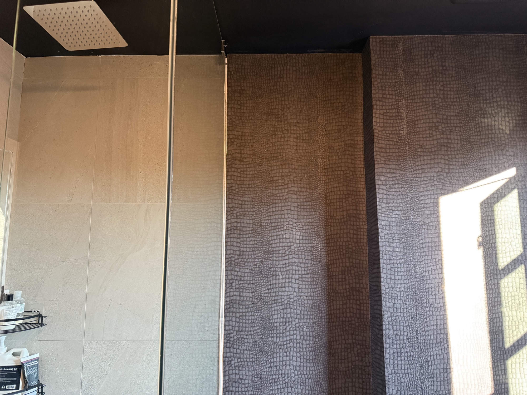 Finished bathroom with painted ceiling, wallpaper and tile